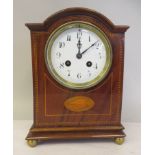 An Edwardian mahogany string inlaid and marquetry mahogany cased bracket clock with a round arch