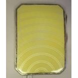 A white metal folding cigarette case with canted corners, engine turned and yellow enamel