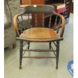 An early 20thC stained oak framed, round back desk chair, the downswept arms on spindled supports,