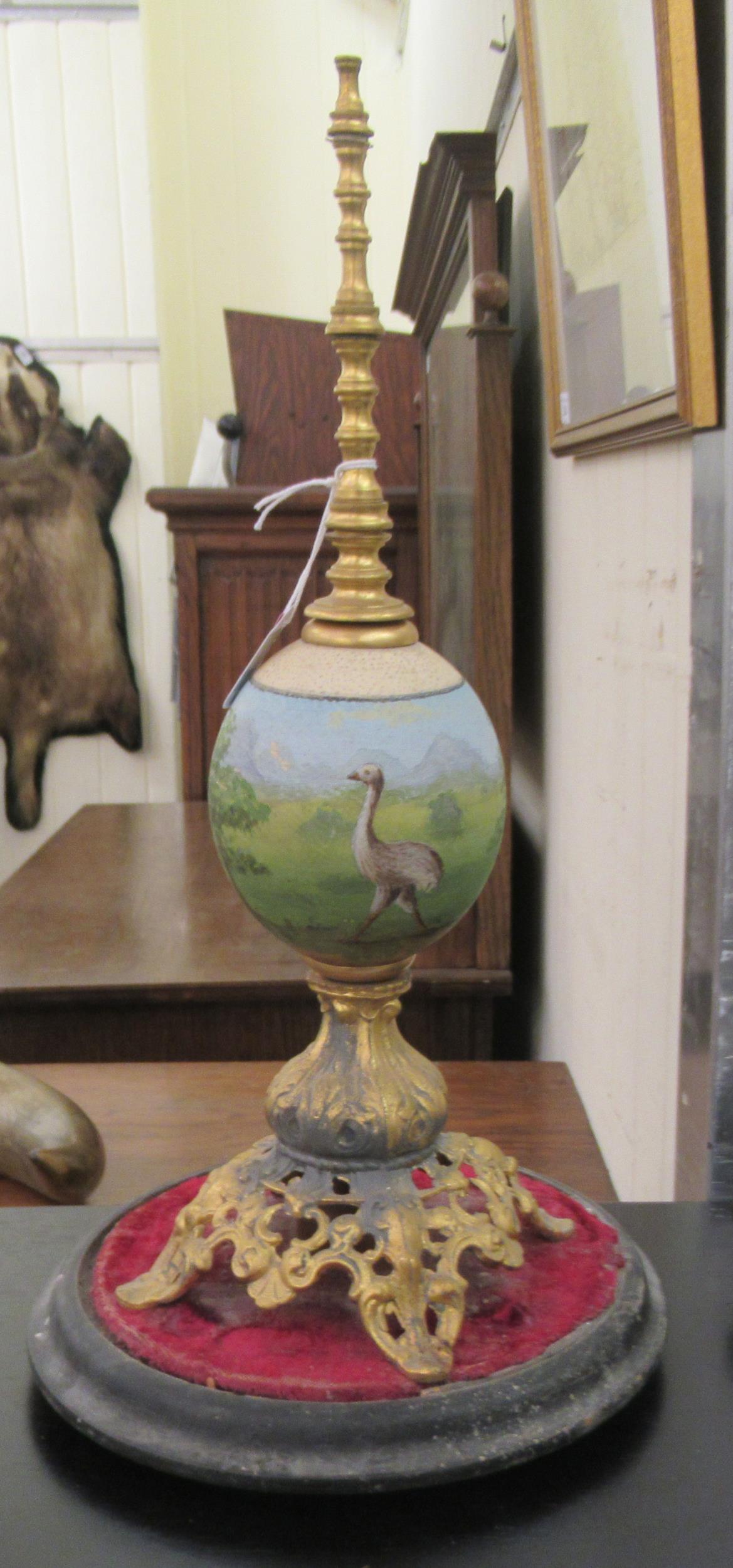 A late 19thC handpainted and gilt metal mounted emu egg centrepiece, on a circular plinth  17"h