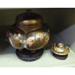 A Satsuma earthenware jar of lobed, bulbous form with a cover, decorated in traditional style with