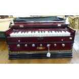 A Bina Deluxe Model harmonium, in a stained mahogany effect case  21"h and outer sleeve