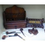 A collection of various smoker's pipes of varying styles; and three various pipe racks: to include