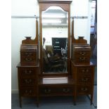 An Edwardian feather inlaid mahogany drop-well dressing table, surmounted by a central, pivoting