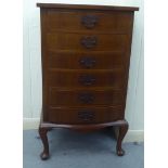 A modern mahogany finished bow front music cabinet, comprising six fall front drawers, raised on