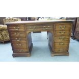 An Edwardian mahogany one piece, nine drawer pedestal desk, raised on bracket plinths  31"h  53"w