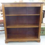 An Edwardian crossbanded satinwood and mahogany bookcase with three height adjustable shelves, on