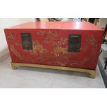 A modern Chinese red lacquered and overpainted storage trunk with straight sides, ornately cast