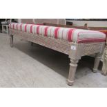 A modern Continental style window seat with a cream and red stripe upholstered, studded and