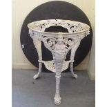 A late Victorian white painted cast iron pub table, featuring term figures, raised on paw feet