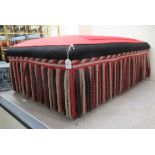 A modern stool, upholstered in panelled floral embroidery and a black and red ground with a deep,