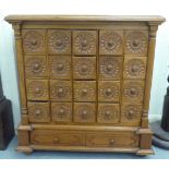 An early 20thC honey coloured mahogany breakfront chest, comprising twenty box drawers with