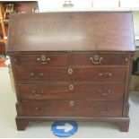 A George III mahogany bureau with a fall front, enclosing a fitted interior, over two short/three