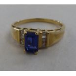 A 10k gold ring, set with a central sapphire, flanked by six diamonds