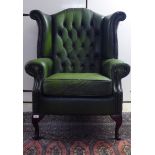 A modern wingback armchair, stud and part button upholstered in green hide, raised on cabriole