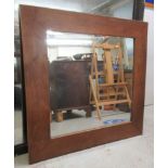 A modern mirror, the bevelled plate set in a hardwood frame  39.5"sq
