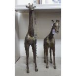 Two similar African brass models, standing giraffes