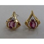 A pair of 10k gold earrings, each set with a pink stone and a diamond