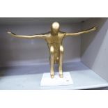 A gilded metal sculpture, a man kneeling with outstretched arms  13"h
