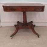 A Regency mahogany tea table with a foldover top, raised on splayed, sabre legs and casters