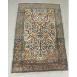 A Persian tree of life design rug, on a beige and blue ground  55" x 36"