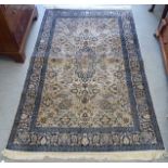 A Persian woollen and silk rug, decorated with dense flora, on a blue and cream coloured ground  72"