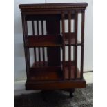 An Edwardian satinwood inlaid mahogany and marquetry three tier revolving bookcase with slatted
