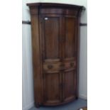 A George III pine and oak one-piece quadrant corner cabinet, having an arrangement of four