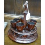 A Victorian style stained and turned mahogany egg cruet, the six pedestal cups set in a galleried