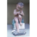 A painted plaster cherub, seated, writing on a tablet  14"h