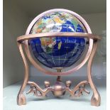 A miniature globe, set with regional hardstone, in a brushed metal gimble style frame  7"h