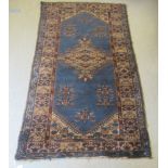A Persian rug with stylised decoration on a blue ground  86" x 48"