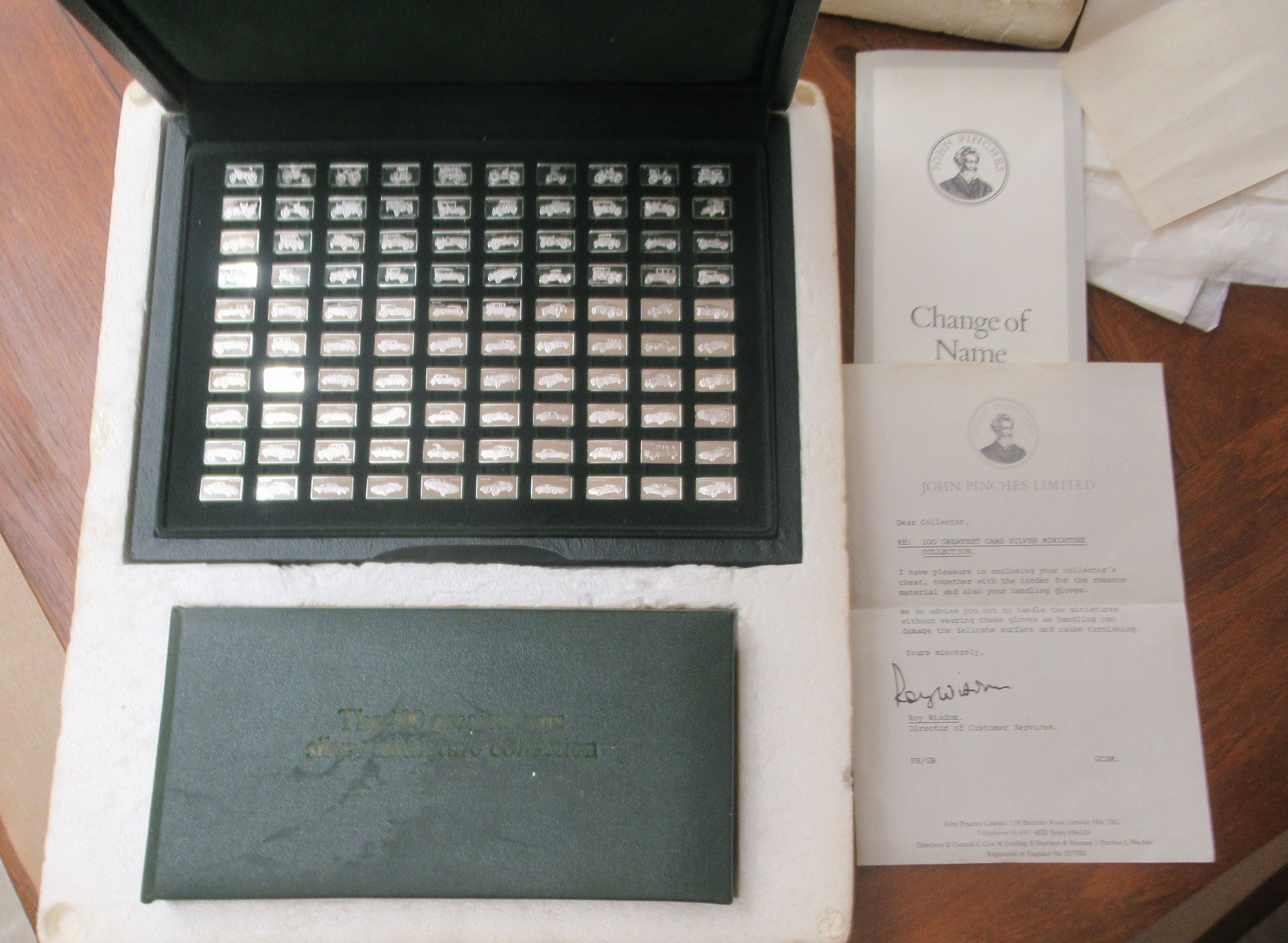 A John Pinchers Limited 'The 100 Greatest Cars Miniature Silver Ingot Collection' with attendant