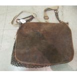 A vintage brown hide gamekeeper's bag with three separate compartments, on a shoulder strap