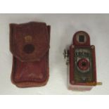 A vintage Coronet Midget mottled iron red Bakelite cased camera with a dedicated protective stitched