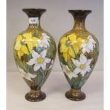 A pair of BM Durtnall stoneware ovoid shape pedestal vases, decorated with daffodils, on a patterned