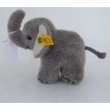 A Steiff grey baby elephant with an ear button  6"h