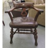 A Victorian mahogany framed captain's style desk chair with a curved, cushion moulded crest, a