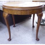 An Art Deco crossbanded and quarter veneered walnut occasional table, raised on tapered legs and pad