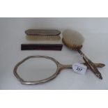 A four piece silver backed and mounted dressing table set comprising a handmirror, hairbrush, comb