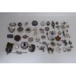 A miscellany of silver and white metal pin badges; brooches; and similar