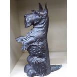 A black painted cast brass door porter, featuring a Highland Terrier, on its hind legs  17"h