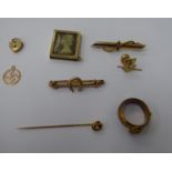 Gold and gold coloured metal items: to include a buckled ring; and a horseshoe mounted bar brooch