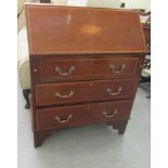 An Edwardian crossbanded marquetry and mahogany bureau, the fall front enclosing a fitted interior