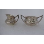 An Edwardian silver twin handled sugar basin, decorated in embossed Art Nouveau taste; and a