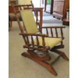 A child's early 20thC American design, stained beech framed rocking chair with an upholstered back