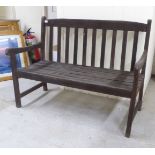 A modern slatted teak garden bench, raised on square legs  48"w