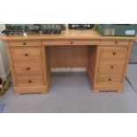 A modern (one piece) light oak, nine drawer, twin pedestal desk, on a bracket plinth  30"h  58"w