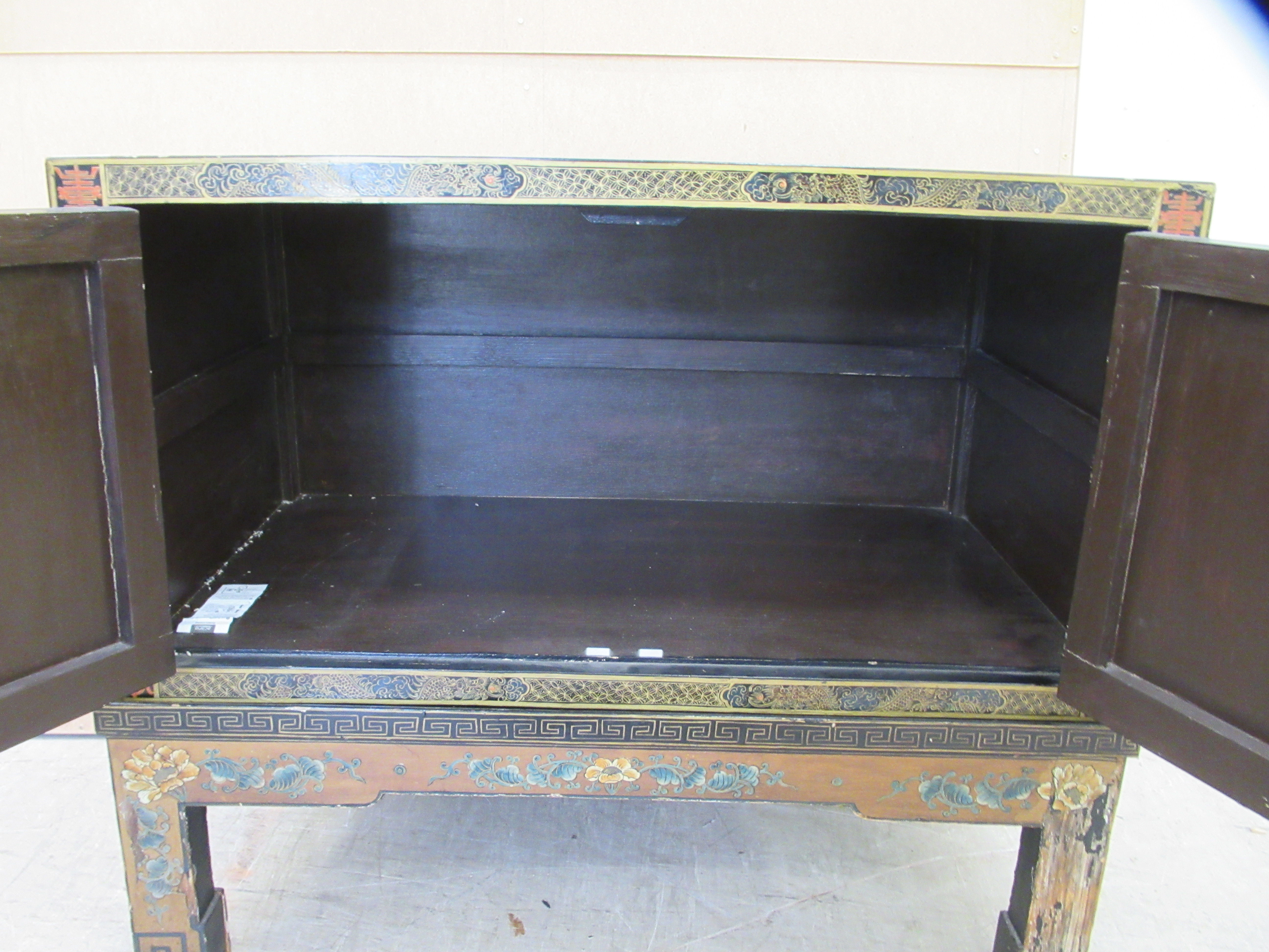 A 20thC Japanese black lacquered low cabinet on stand with two doors, decorated with traditional - Image 5 of 6