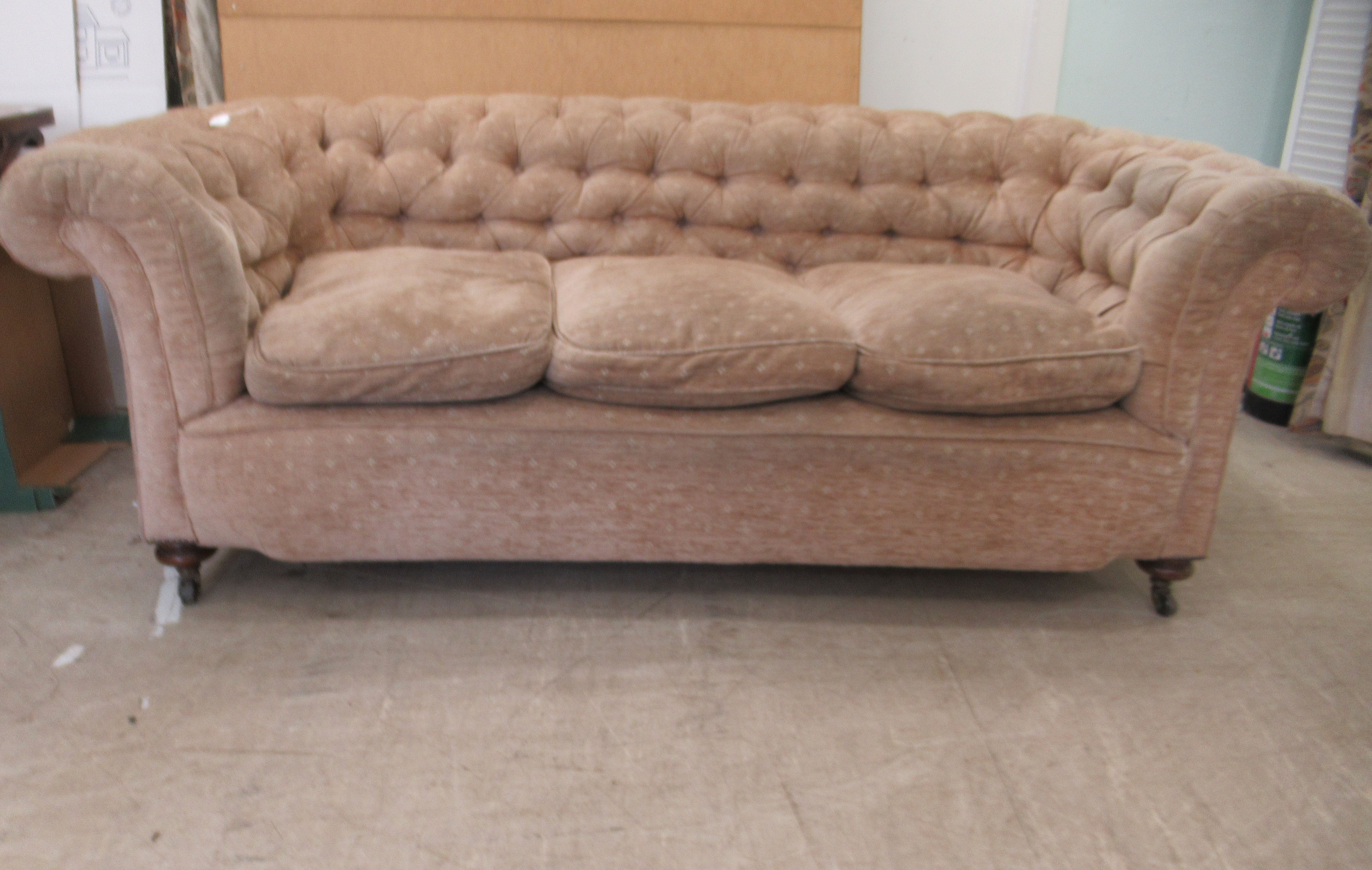 An early 20thC and later upholstered Chesterfield, raised on turned forelegs and casters  74"w